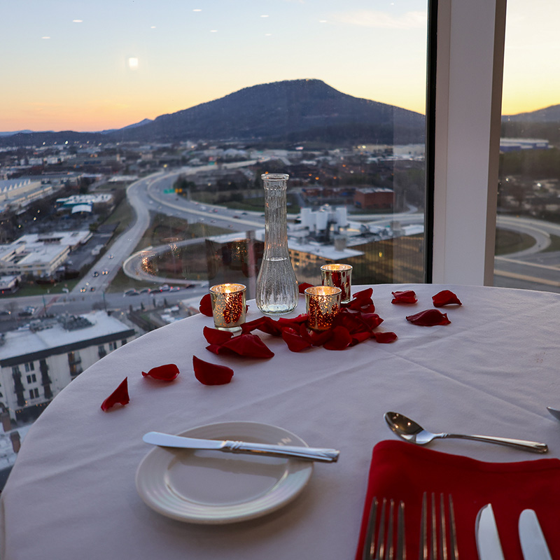 A table with candles and rose petals overlooking the sunset behind Lookout Mountain in Chattanooga, Tennessee.